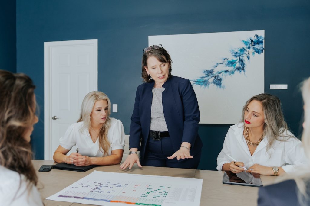 People gathered around a table discussing graphs at a leadership meeting