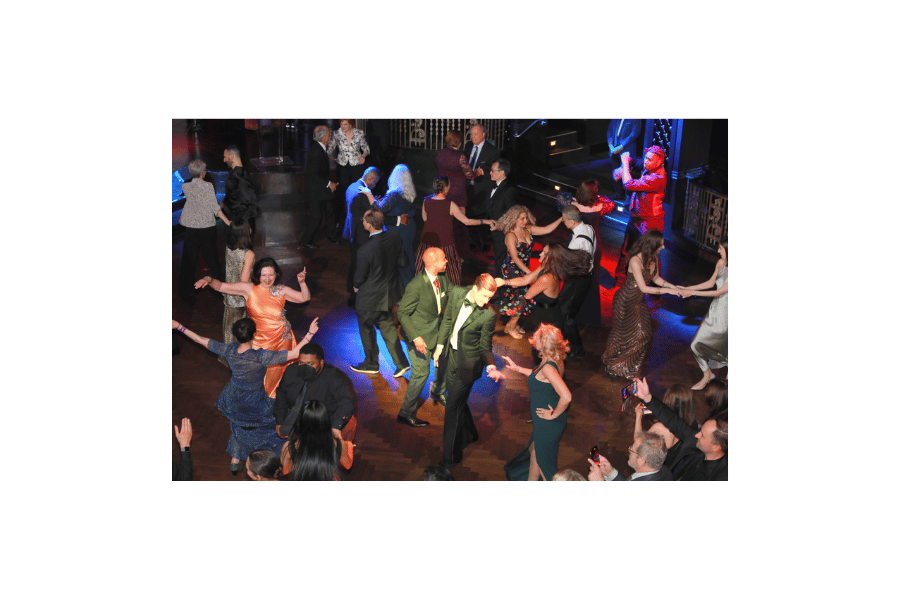 People in formal wear dancing in a ballroom
